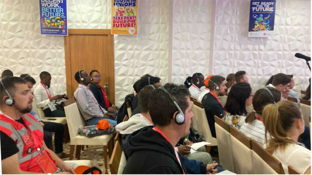 Participants of Global Youth Festival at BWI listening to a speaker on headphones